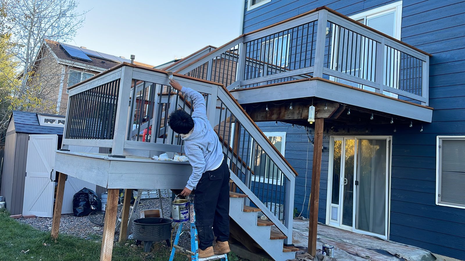 Alvarez crew member on a ladder painting deck railings