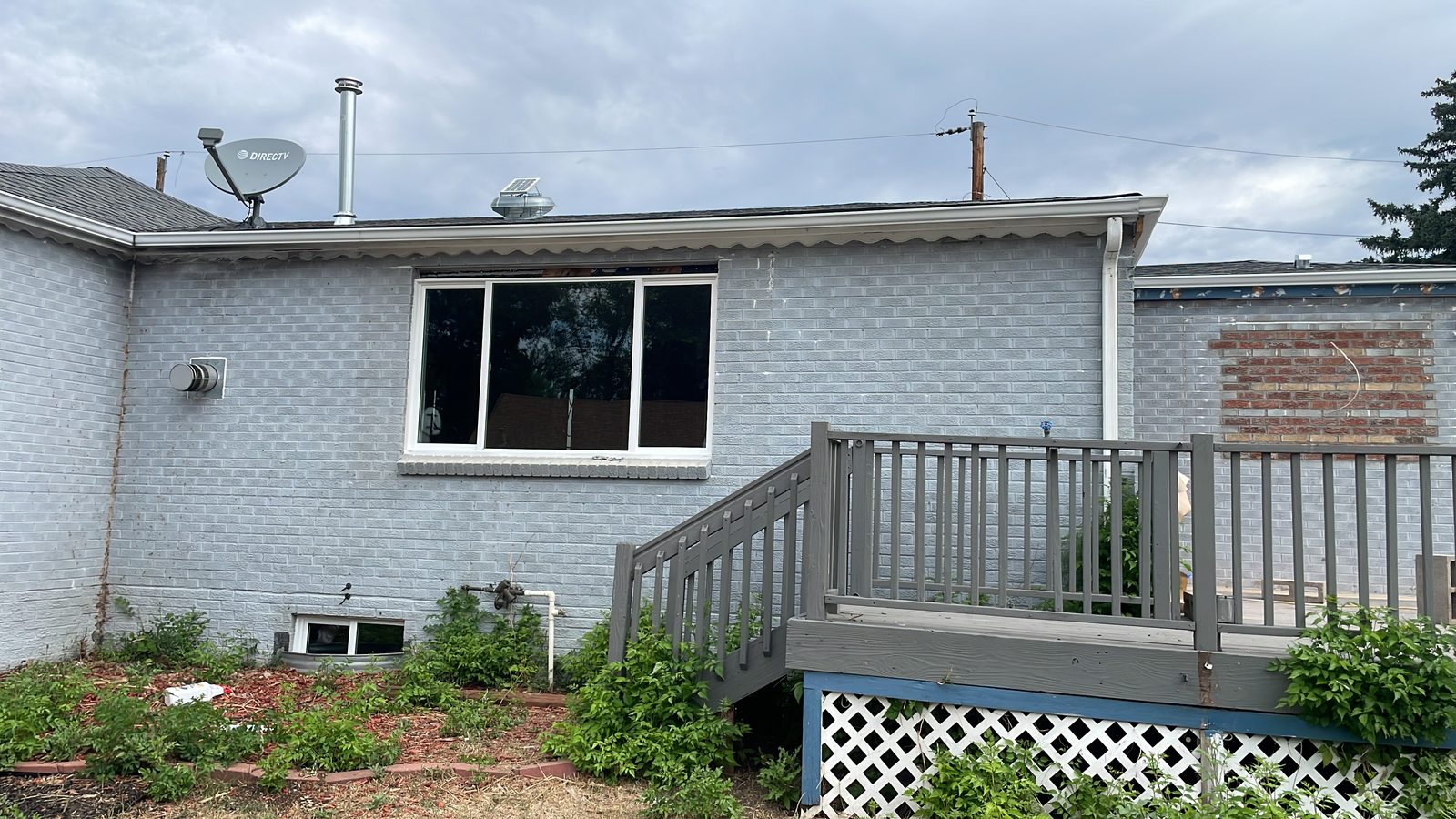 Before: Denver metro · Brick ranch repaint · Deep sage green, black gutters